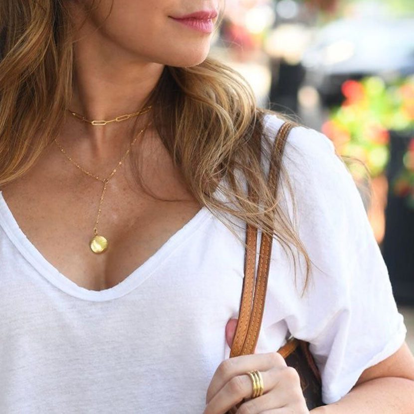Lifestyle image of a woman wearing gold necklaces and rings by Peterson MADE