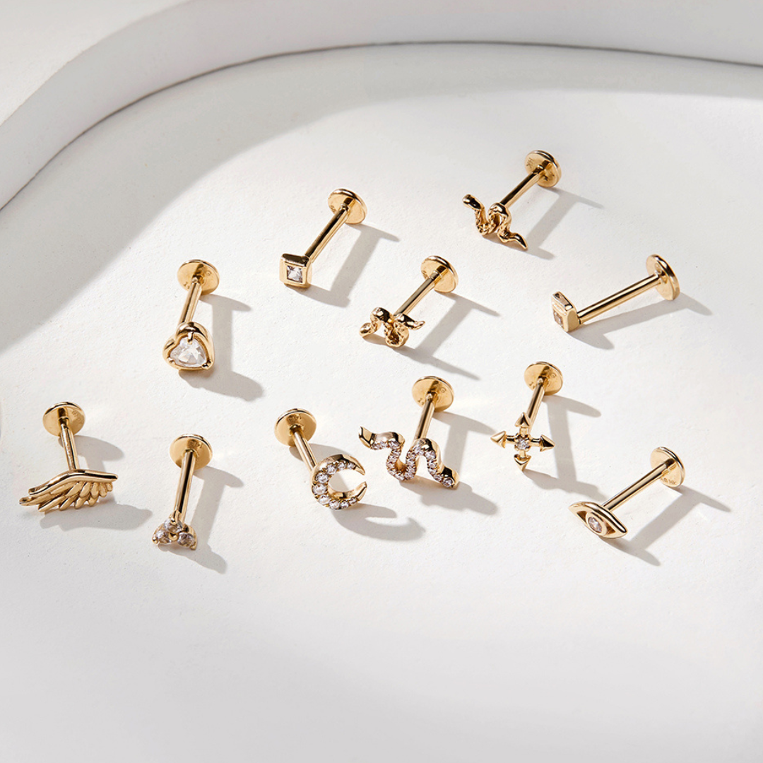 A collection of 14k Gold Threadless Tops shown attached to flatback posts on a white background. 