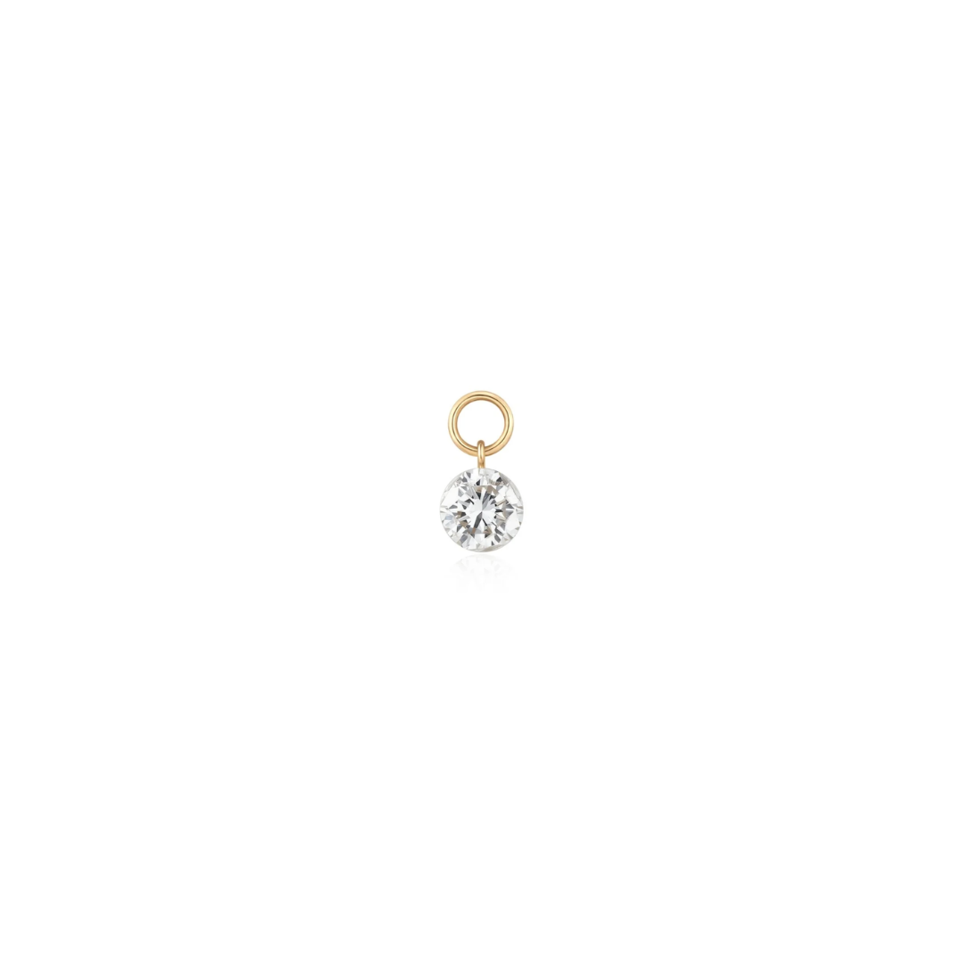 A brilliant-cut lab-grown diamond is invisibly set in a minimalist 14k yellow gold drop charm shown on a white background. 