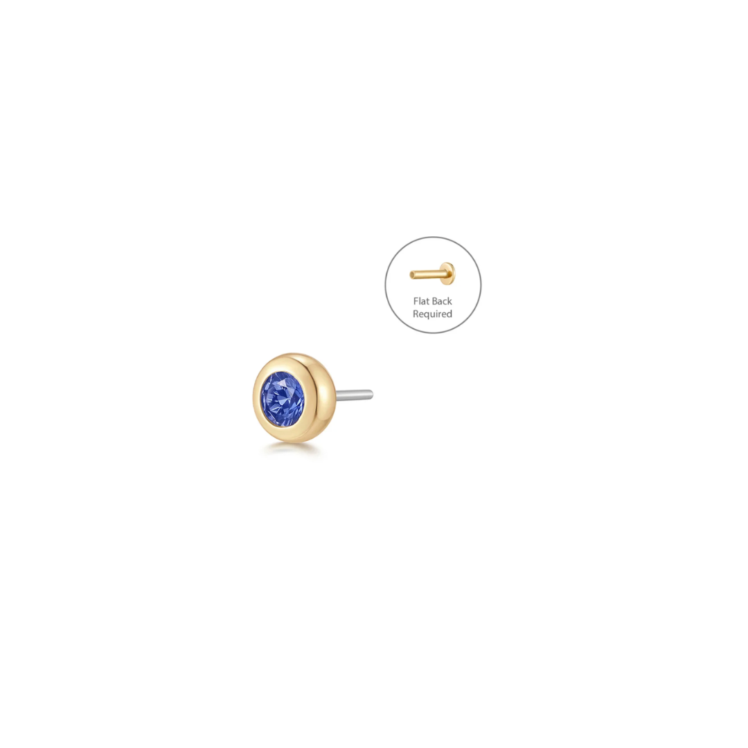 Side perspective of a lab-grown blue sapphire set in a polished 14k gold 4mm bezel for a clean, timeless look, shown on a white background. 