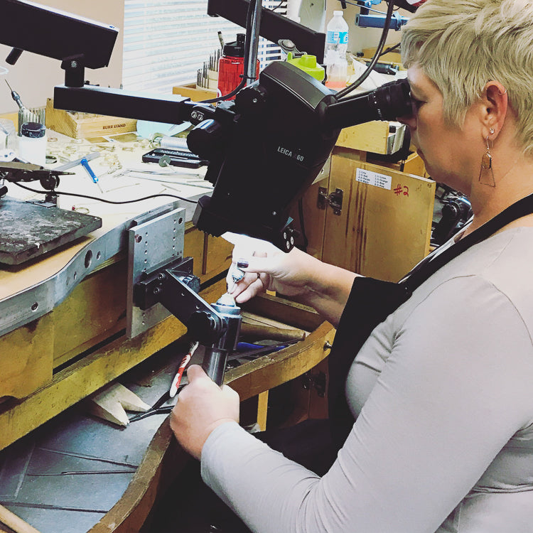 Barb Peterson working on jewelry under a microscope. Handmade jewelry by Peterson MADE. 