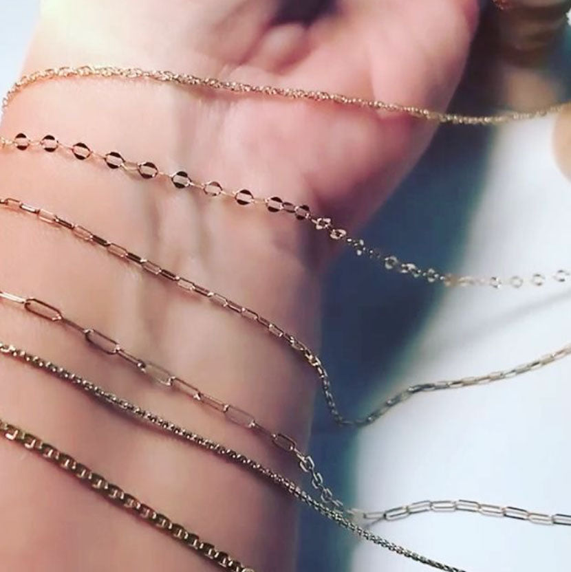 A wrist with 14k gold chain draped to show the Peterson MADE chain options. 