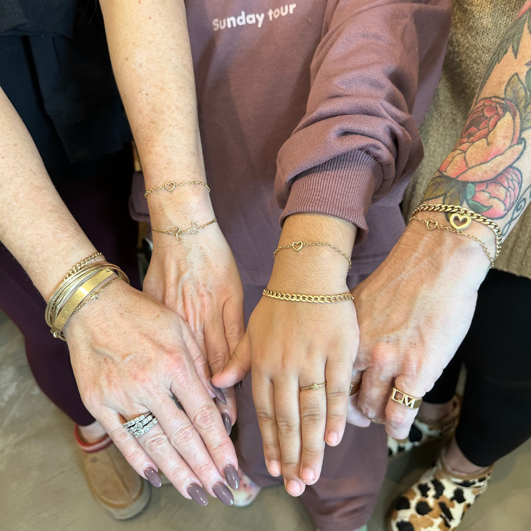 4 wrists and hands featuring 14k gold permanent jewelry - bracelets and charm links - by Peterson MADE