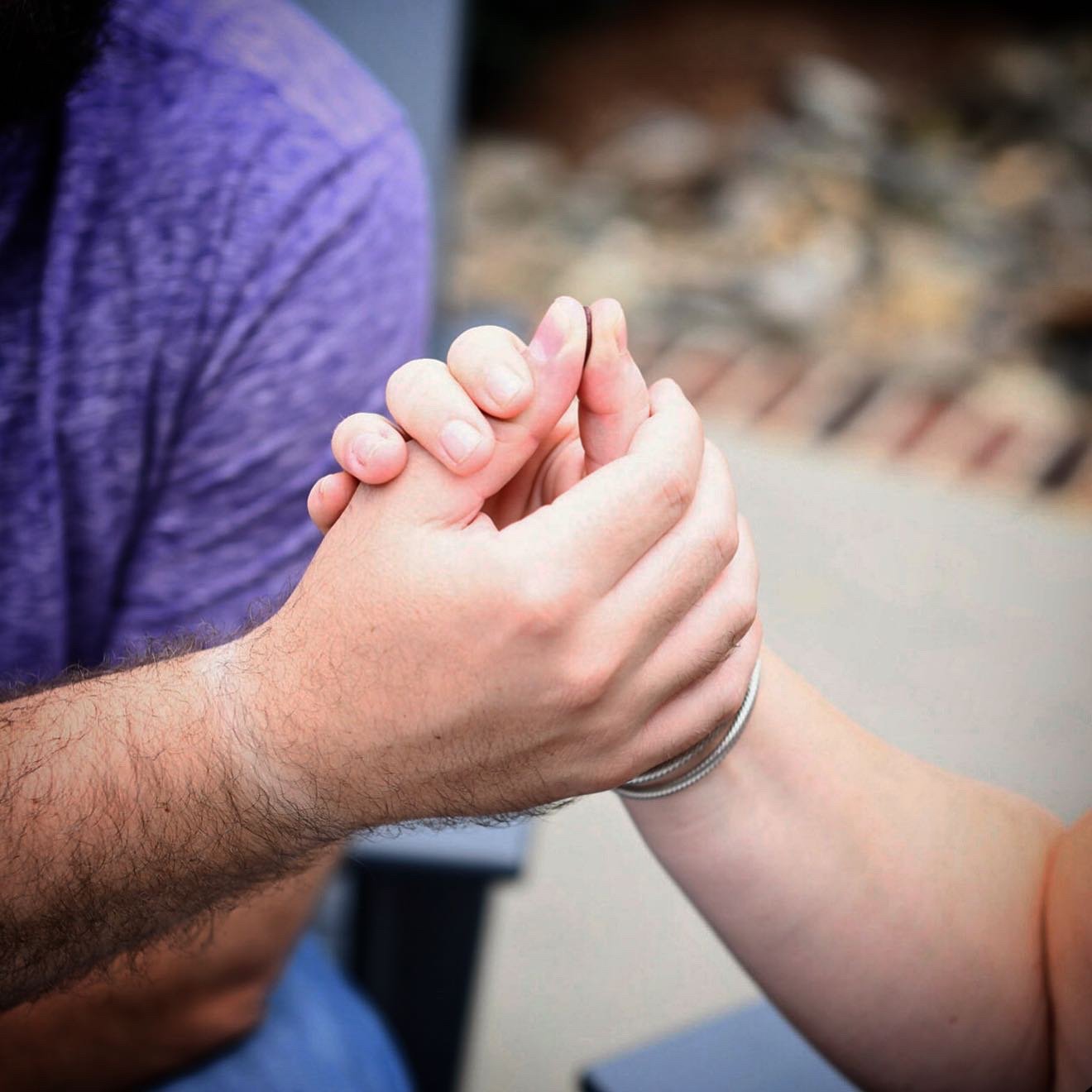 a couple's hands capturing a custom fingerprint charm by Peterson MADE